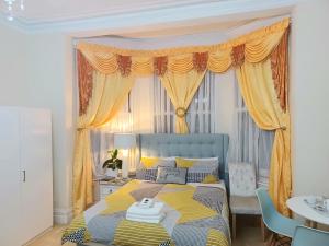 a bedroom with a bed with yellow curtains at Gabriel Guesthouse in Rhyl