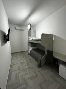 Kleines Zimmer mit einem Schreibtisch und einem Tisch in der Unterkunft Alloggio Pulcinella 2 Affittacamere in Acerra