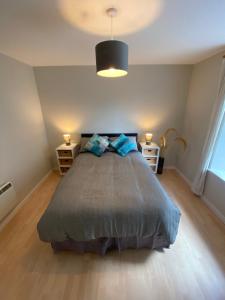 a bedroom with a bed with two blue pillows at Lombard Hide Away in Inverness