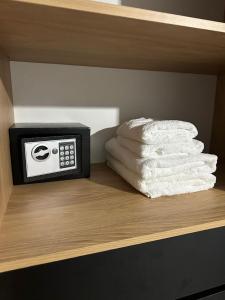a shelf with a alarm clock and towels on it at Casa Valentino in Rafaela
