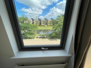 a window with a view of a house at Quiet Luxe Home with GYM and Free Parking in Thamesmead