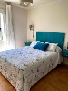 a bedroom with a large bed with a blue headboard at 4 habitaciones, jardín y vistas al mar in Sanxenxo