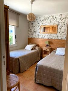 a hotel room with two beds and a window at 4 habitaciones, jardín y vistas al mar in Sanxenxo