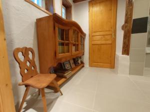 une chaise en bois dans une chambre avec une armoire en bois dans l'établissement La Cigogne dorée Gite de charme 4 étoiles, à Schiltigheim