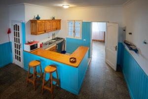 a blue kitchen with a counter and stools in it at Casa el Mar apartamento Pescador in Lomo de Mena