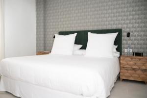 a large white bed with white sheets and pillows at The Royal Garden by LUCIA DE SU in Santa Cruz de Tenerife