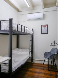 a room with two bunk beds and a chair at Aayu Chulia in George Town