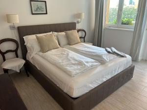 Una cama con sábanas blancas y almohadas en un dormitorio en Agriturismo Al Robale, en Almenno San Bartolomeo