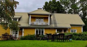 una casa amarilla con una mesa y sillas en el patio en Valkolan kartano, vanha tupa en Hankasalmi