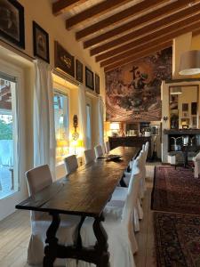 uma grande sala de jantar com uma mesa longa e cadeiras brancas em Agriturismo Al Robale em Almenno San Bartolomeo