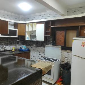 een keuken met een fornuis en een witte koelkast bij شاليه الفرح in El Alamein