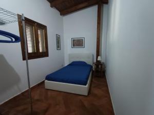 een slaapkamer met een bed met een blauwe deken bij Casa Villaggio Moresco basso in Peschici