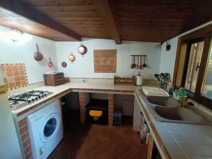 een keuken met een fornuis bovenoven naast een gootsteen bij Casa Villaggio Moresco basso in Peschici