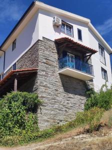 a building with a balcony on the side of it at Encosta do Pinhão in Casal de Loivos
