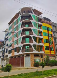 un edificio alto con finestre colorate su una strada di HOTEL LA BELLA Y EL LEON a Huánuco
