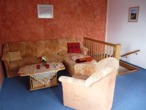 ein Wohnzimmer mit einem Sofa, einem Tisch und Stühlen in der Unterkunft Ferienwohnung Riedl in Klingenthal
