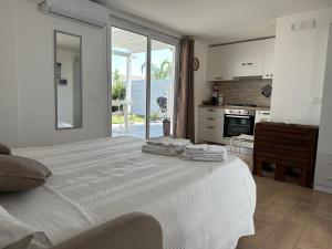 マリーナ・ディ・ラグーザにあるVilla Matildeの白いベッドルーム(大型ベッド1台付)、キッチンが備わります。