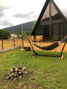 a hammock in front of a log cabin at Cozy Hills in Borjomi