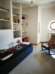 a bedroom with a bed and a chair in a room at Dimora alla Villa in Ostuni