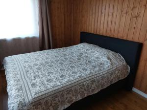 a bed with a white blanket on it in a room at Oruheina Bungalow 