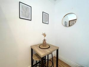 un tavolo con un vaso e uno specchio su un muro di Flat 12, 10 St John’s Road a Bournemouth