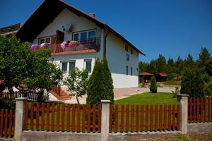 a house with a red fence in front of it at Guesthouse Kovačević in Korenica