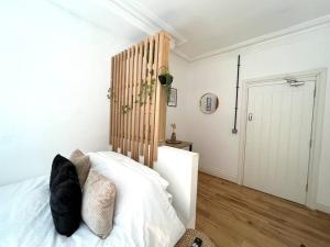 una camera con letto bianco e testiera in legno di Flat 12, 10 St John’s Road a Bournemouth