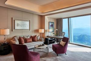 een woonkamer met een bank en stoelen en een bureau bij The St. Regis Shenzhen in Shenzhen