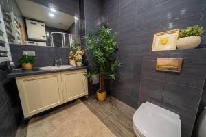a bathroom with a toilet and a sink with plants at Cozy apartment in Santariškės in Vilnius
