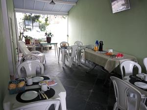 un comedor con mesas y sillas con platos. en Vista Mar Suítes, en Cabo Frío