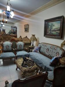 ein Wohnzimmer mit einem Sofa, Stühlen und einem Tisch in der Unterkunft Apartment For Rent at Gamal Abdelnasser Street directly near from the sea in Alexandria