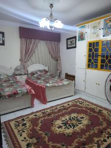 ein Schlafzimmer mit 2 Betten und einem Teppich auf dem Boden in der Unterkunft Apartment For Rent at Gamal Abdelnasser Street directly near from the sea in Alexandria