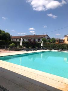ein großer blauer Pool mit Stühlen und Sonnenschirmen in der Unterkunft Hotel La Rocca in Nogarole Rocca