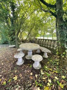 einen Steintisch und Bänke in einem Park in der Unterkunft Maison Corbionne - Au cœur du Perche in Condeau