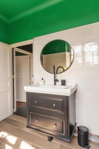 ein Bad mit einem Waschbecken und einem Spiegel in der Unterkunft Maison Corbionne - Au cœur du Perche in Condeau