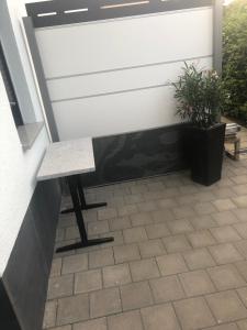 a bench next to a wall with a plant at Ferienwohnung in Würm in Pforzheim