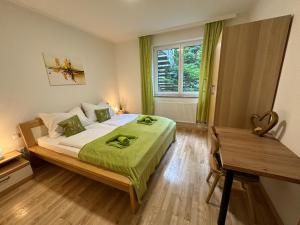 Schlafzimmer mit einem Bett, einem Schreibtisch und einem Fenster in der Unterkunft Pöstlingbergoase in Linz