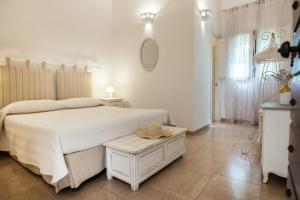 a white bedroom with a bed and a table at Antica Masseria Ficazzana - Tenuta in Marina di Pescoluse