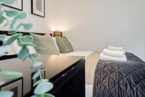 a bedroom with a bed and a dresser with towels at Hidden Gem with En-Suites in West Hampstead in London
