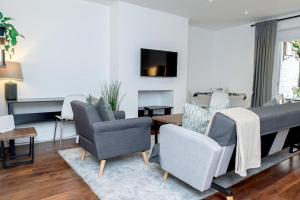 a living room with two chairs and a couch at Hidden Gem with En-Suites in West Hampstead in London