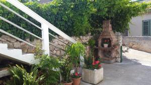 un jardin avec un mur en pierre et un escalier orné de plantes dans l'établissement Apartment Nera, à Sali