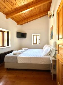 a bedroom with a bed and a tv on the wall at Myrtillo I Luxury Traditional House in Spanokhórion