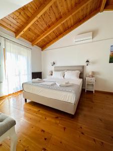 a bedroom with a large bed and a wooden ceiling at Myrtillo I Luxury Traditional House in Spanokhórion