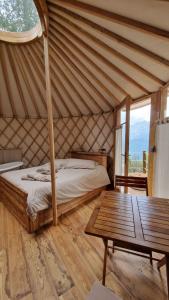 1 dormitorio en una yurta con cama y mesa en MonvisoRelax, en Ostana