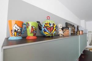 vier bunte Vasen auf einem Regal in der Unterkunft JUST-ROOM. Apartamento Angelica in Camargo