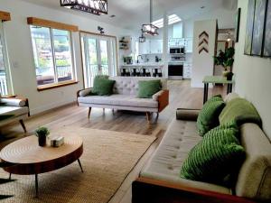 a living room with two couches and a table at Oasis Riverfront House -10 min to Sequoia in Three Rivers
