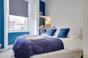 ベリック・アポン・トゥィードにあるHomesly Guest Rooms, Comfortable En-suite Guest Rooms with Free Parking and Self Check-inの青い壁の大きなベッドのある寝室