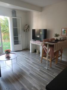 un salon avec une table et une télévision dans l'établissement La rose des sable, à Garges-lès-Gonesse