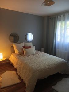 - une chambre avec un lit doté d'une couette blanche et d'une fenêtre dans l'établissement La rose des sable, à Garges-lès-Gonesse