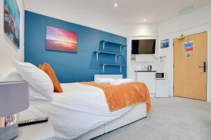 Un dormitorio con una pared azul y una cama en Homesly Guest Rooms, Comfortable En-suite Guest Rooms with Free Parking and Self Check-in, en Berwick-Upon-Tweed